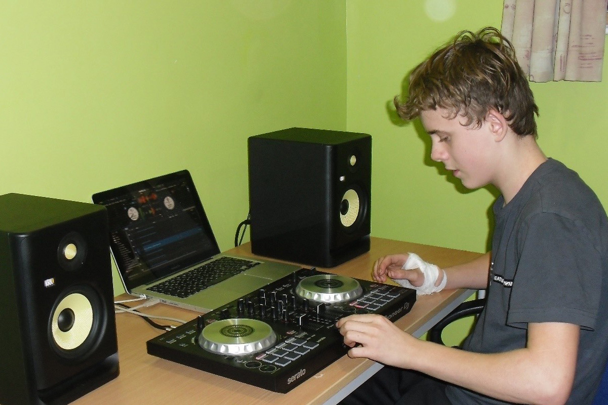 A student relaxing with a music mixing desk