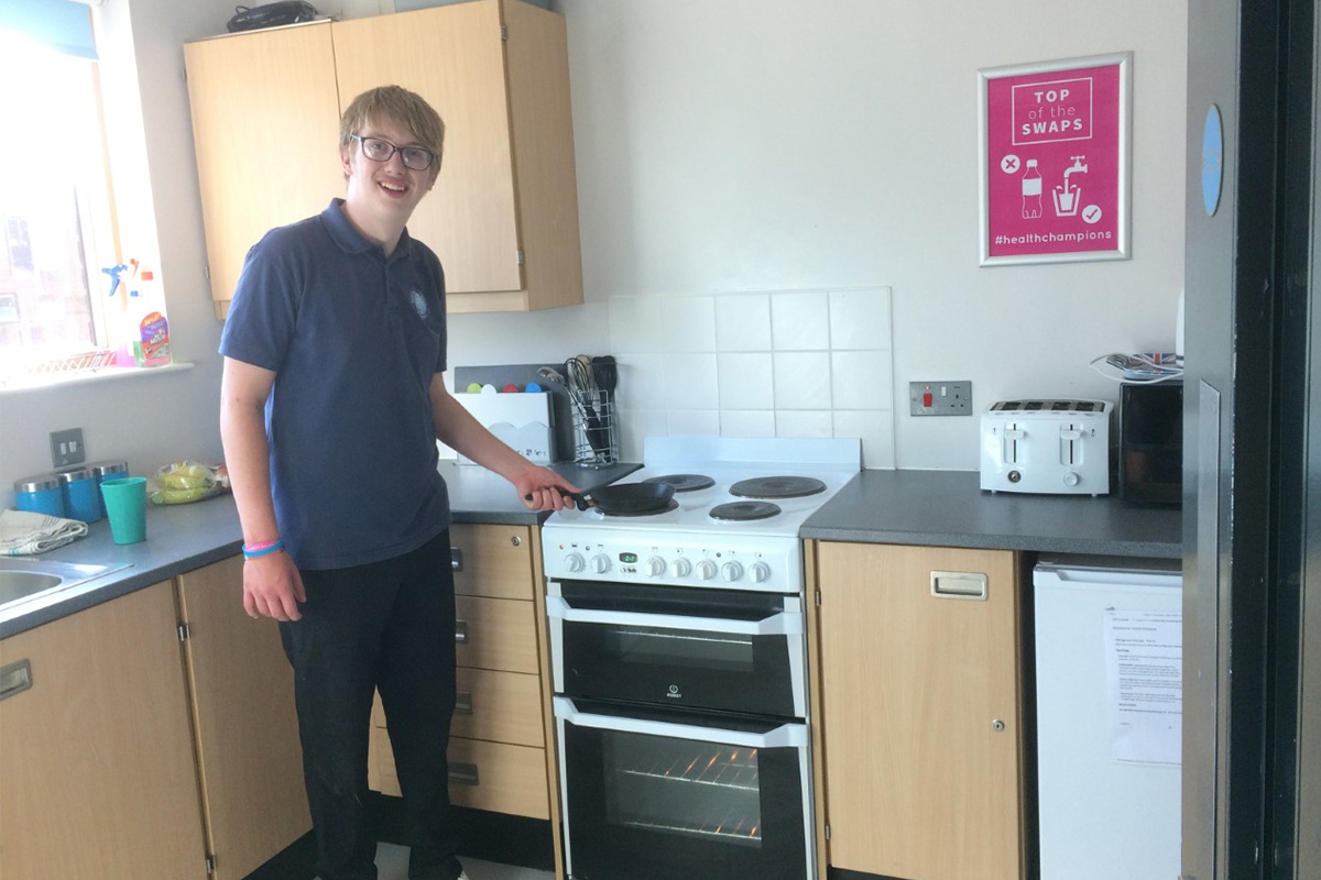 A student cooking in their residential kitchen