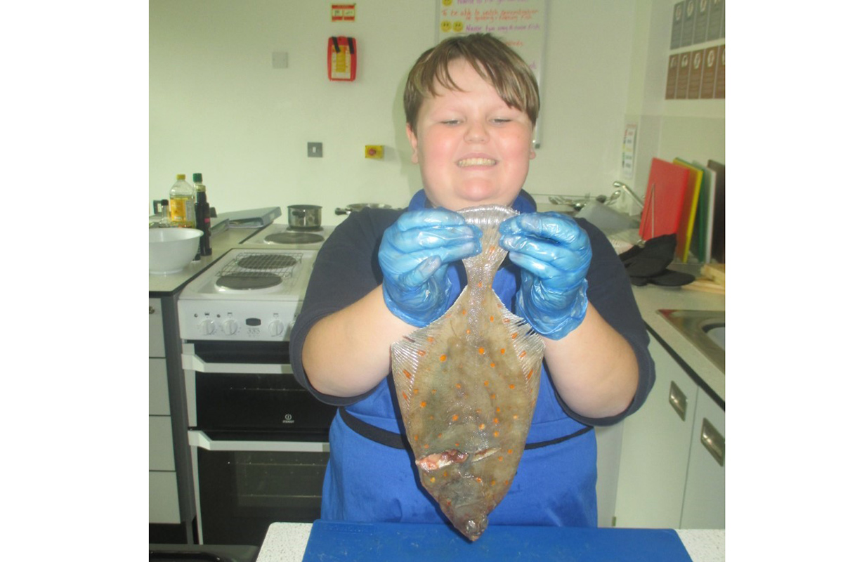 Student with a fresh fish (plaice)